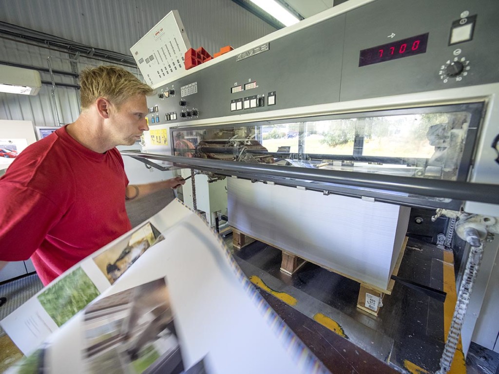Fredrik Stewenhag tryckare och hundtränare/uppfödare plockar ett ark ur pressen för kontroll.